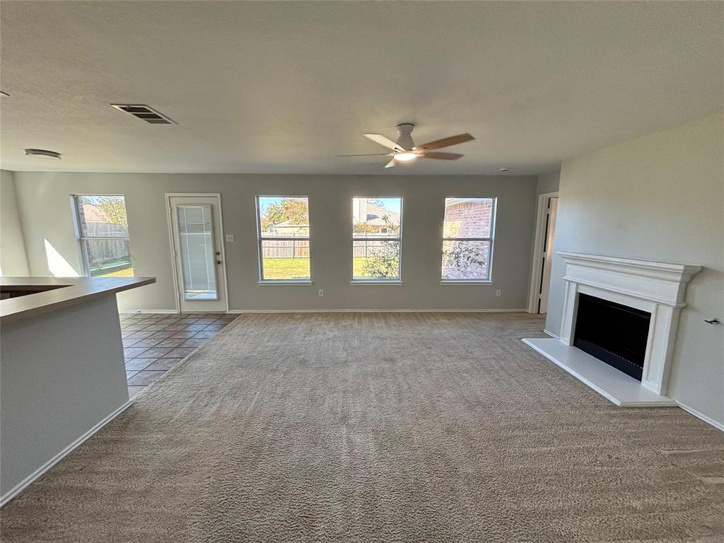 1003 Windsor Lane Forney, TX 75126 - Photo 7 of 20 a view of an empty room with a fireplace and a window