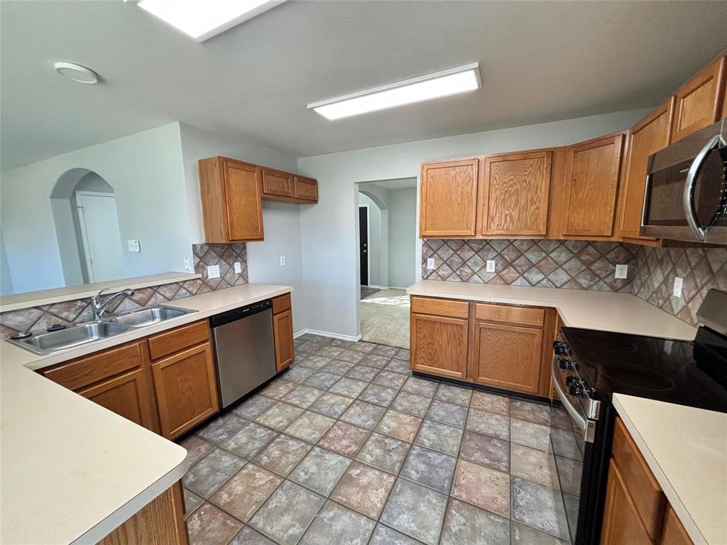 1003 Windsor Lane Forney, TX 75126 - Photo 10 of 20 a kitchen with stainless steel appliances granite countertop a sink stove and cabinets