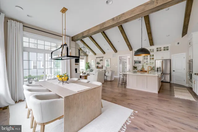 a kitchen with stainless steel appliances granite countertop a stove and a view of living room
