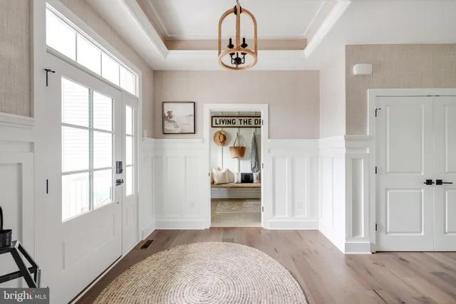 a view of a bedroom with wooden floor window and front door