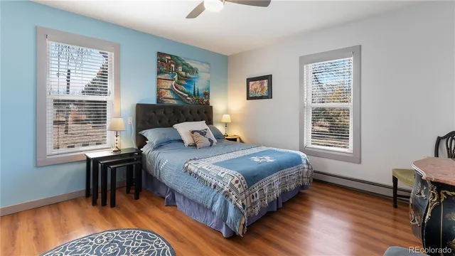 a bedroom with a bed wooden floor and window