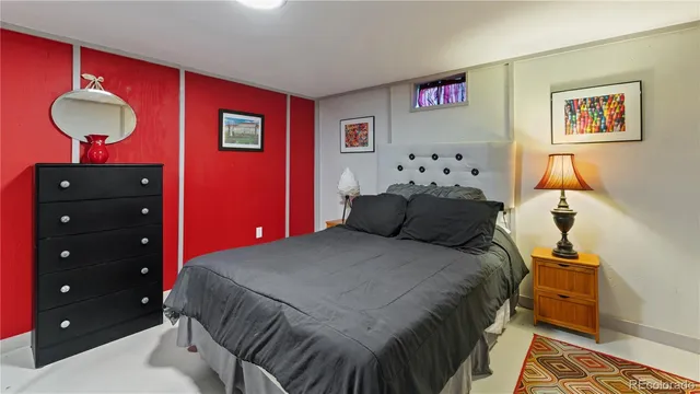 a bedroom with a bed and a lamp on dresser