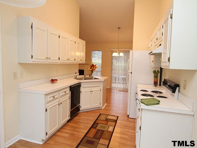 3605 Christine Court Raleigh, NC 27604 - Photo 5 of 12 a kitchen with a refrigerator a stove and white cabinets