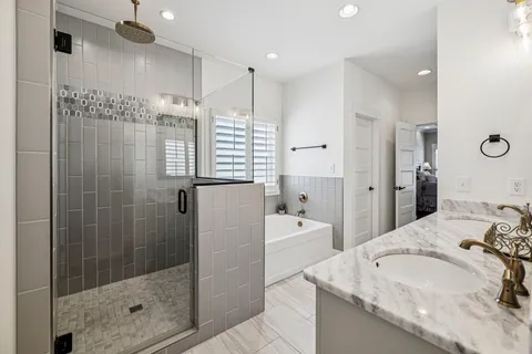 a bathroom with a granite countertop sink vanity mirror bathtub shower and a toilet