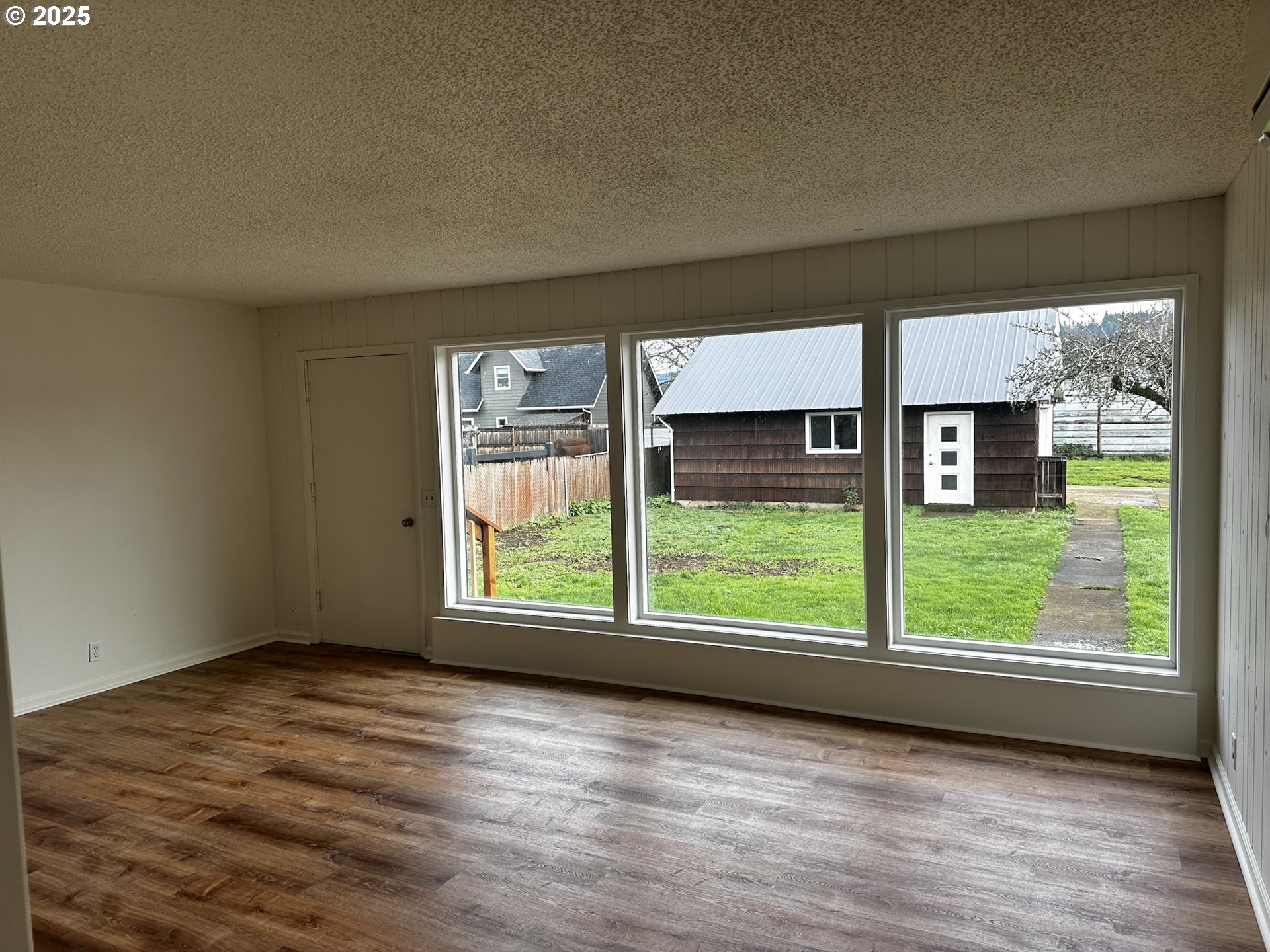 818 South 1st Street Cottage Grove, OR 97424 - Photo 8 of 22 an empty room with wooden floor and windows