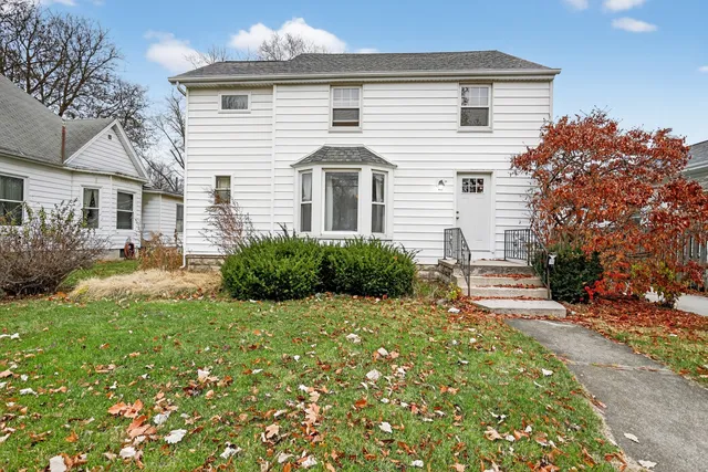a view of a house with backyard and sitting area