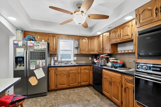 a kitchen with stainless steel appliances granite countertop a sink dishwasher stove top oven and cabinets with wooden floor