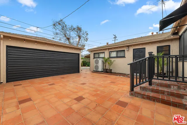 a backyard of a house with table and chairs