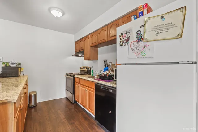 a kitchen with stainless steel appliances granite countertop a refrigerator and a stove