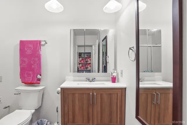 a bathroom with a sink vanity mirror and toilet