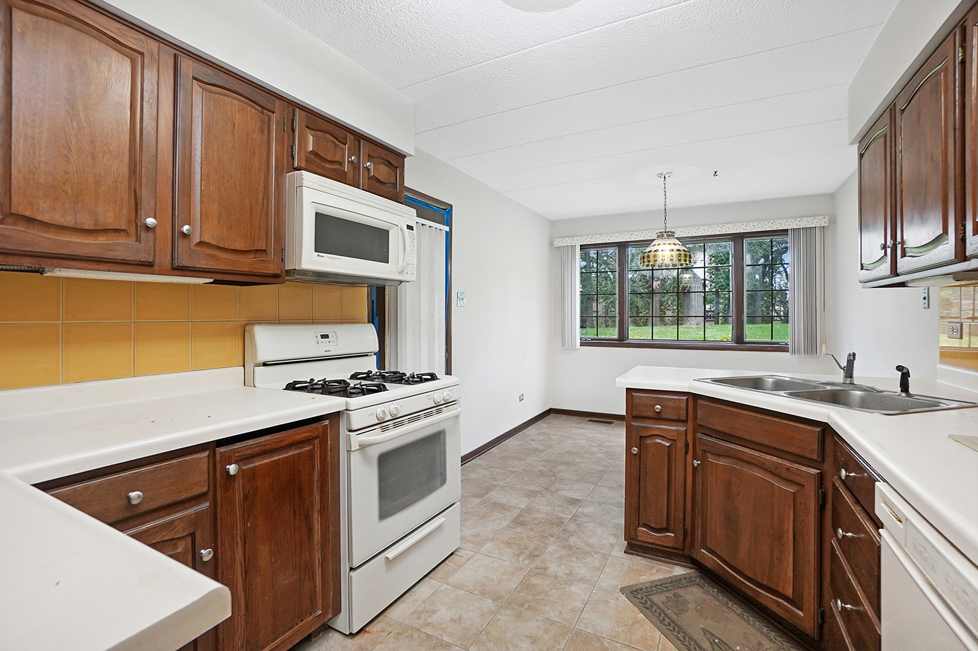 13222 South Oak Ridge Trail, Unit 1A Palos Heights, IL 60463 - Photo 6 of 21 a kitchen with stainless steel appliances granite countertop a sink stove and microwave