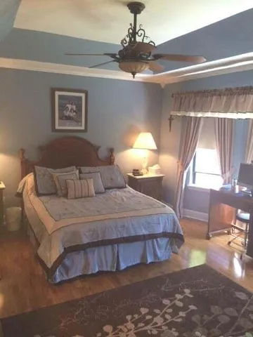 a bedroom with a bed and wooden floor