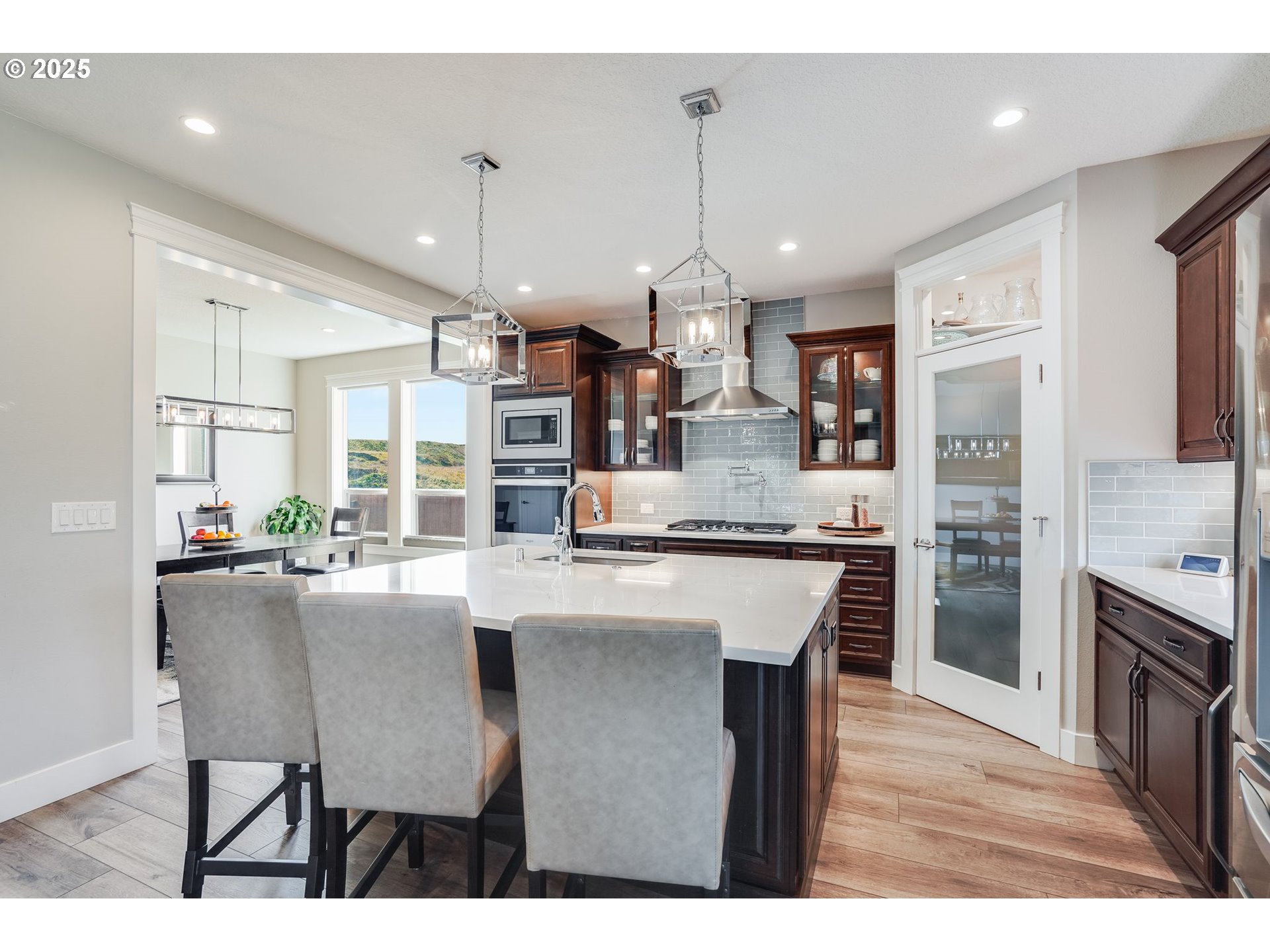 1709 South 43rd Place Ridgefield, WA 98642 - Photo 6 of 24 a kitchen with kitchen island granite countertop a table chairs refrigerator and microwave