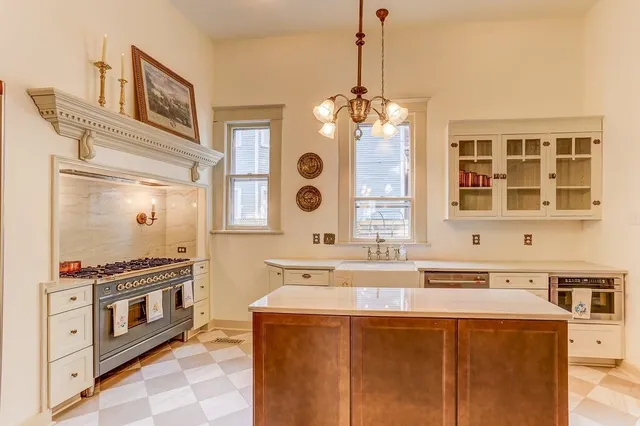 a kitchen with stainless steel appliances a stove a sink and a chandelier