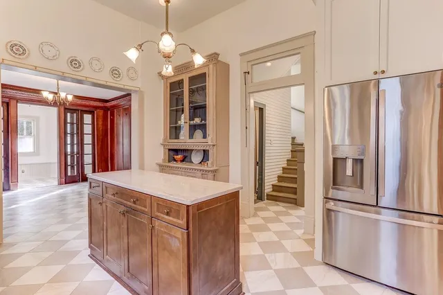 a kitchen with stainless steel appliances a refrigerator and a chandelier