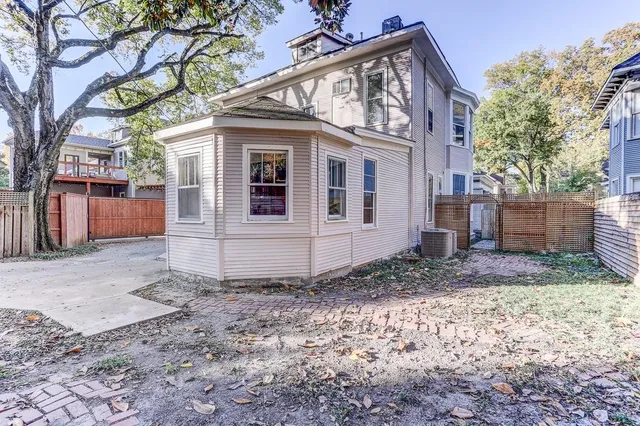 a view of a house with a yard and large tree