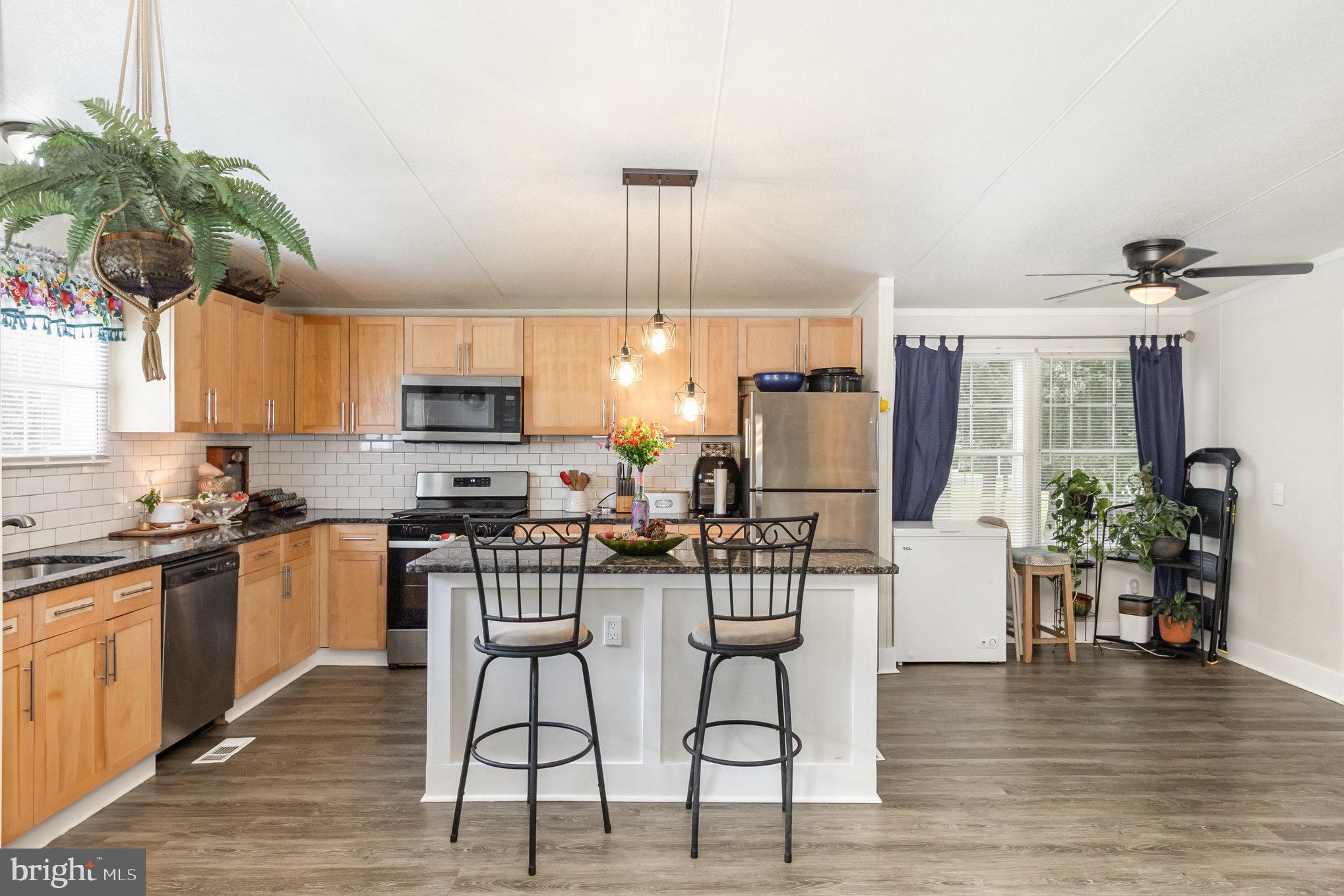 4041 Conowingo Road, Unit 30 Darlington, MD 21034 - Photo 11 of 40 a kitchen with stainless steel appliances kitchen island granite countertop a table and chairs in it