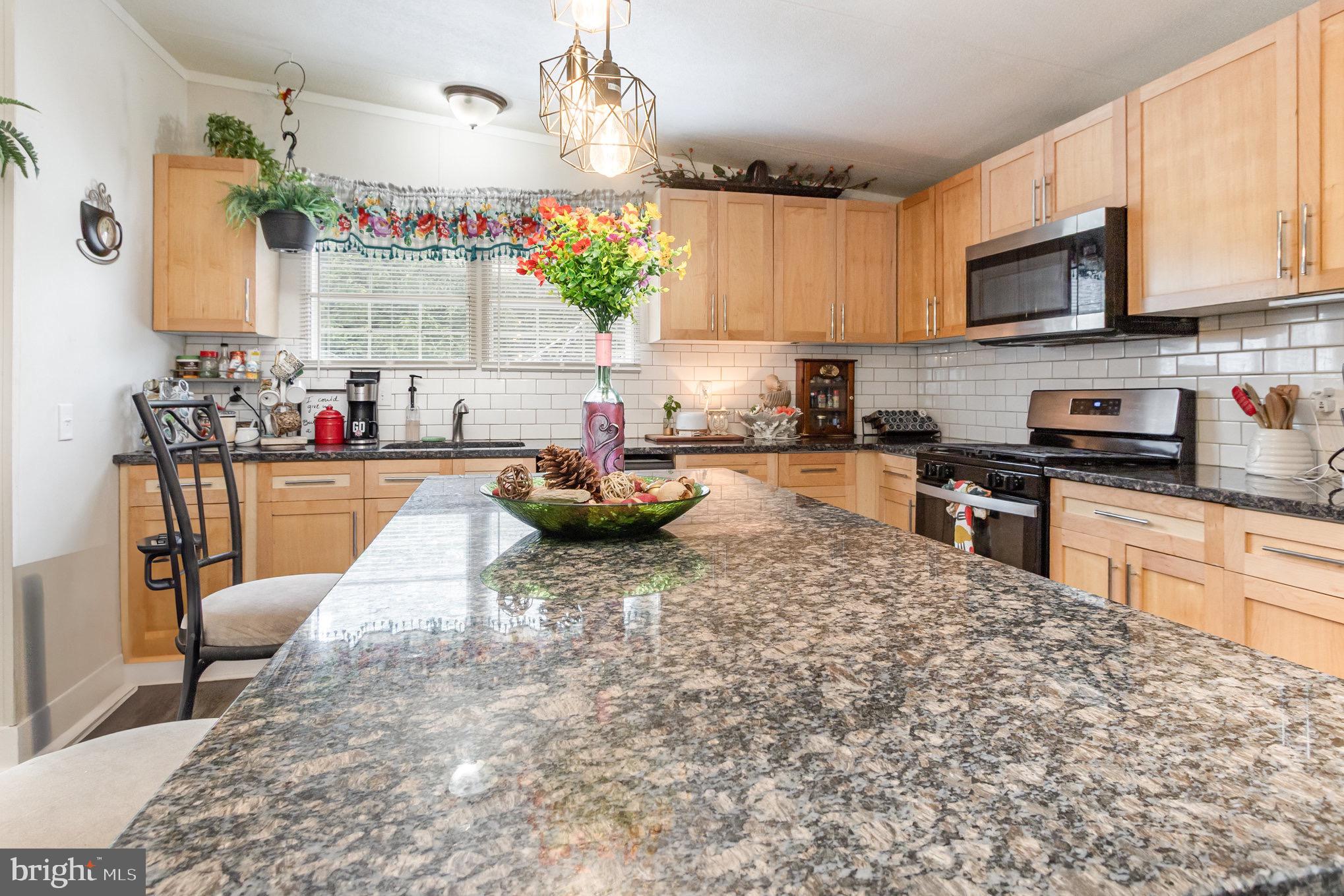 4041 Conowingo Road, Unit 30 Darlington, MD 21034 - Photo 14 of 40 a kitchen with stainless steel appliances kitchen island granite countertop a sink dishwasher stove top oven and cabinets with wooden floor