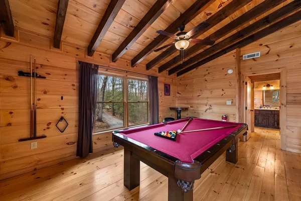 a kitchen with stainless steel appliances a refrigerator a stove a dining table and chairs with wooden floor