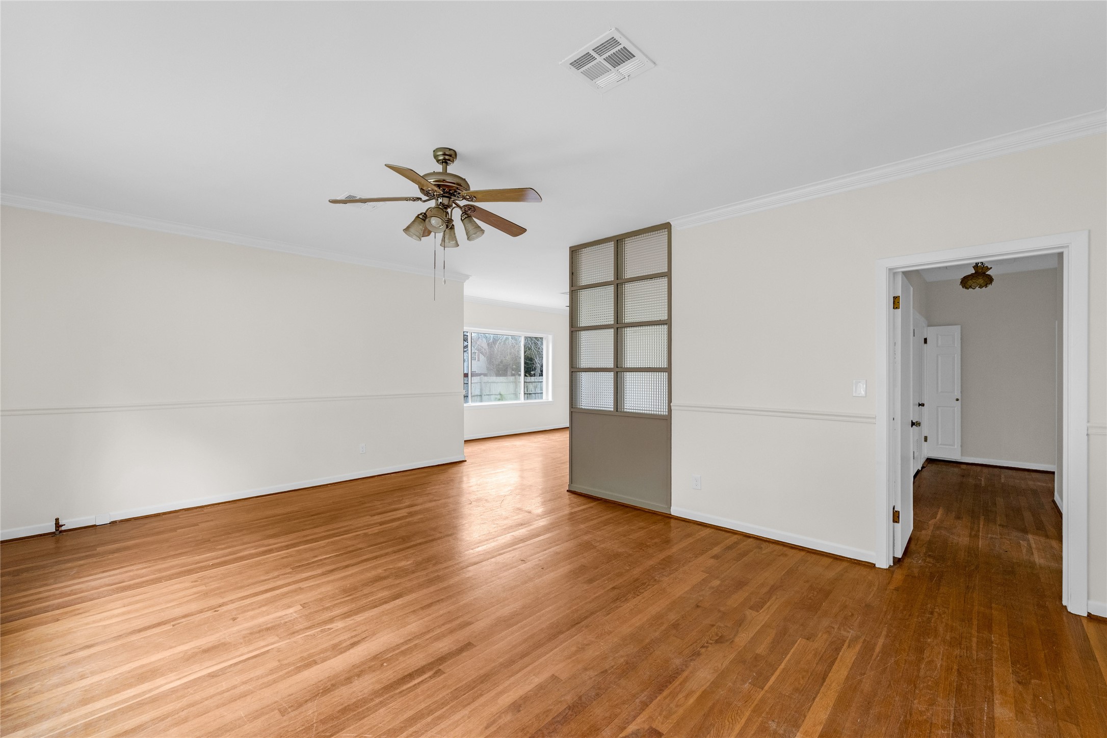 2527 Avenue G Rosenberg, TX 77471 - Photo 7 of 35 an empty room with wooden floor and chandelier fan
