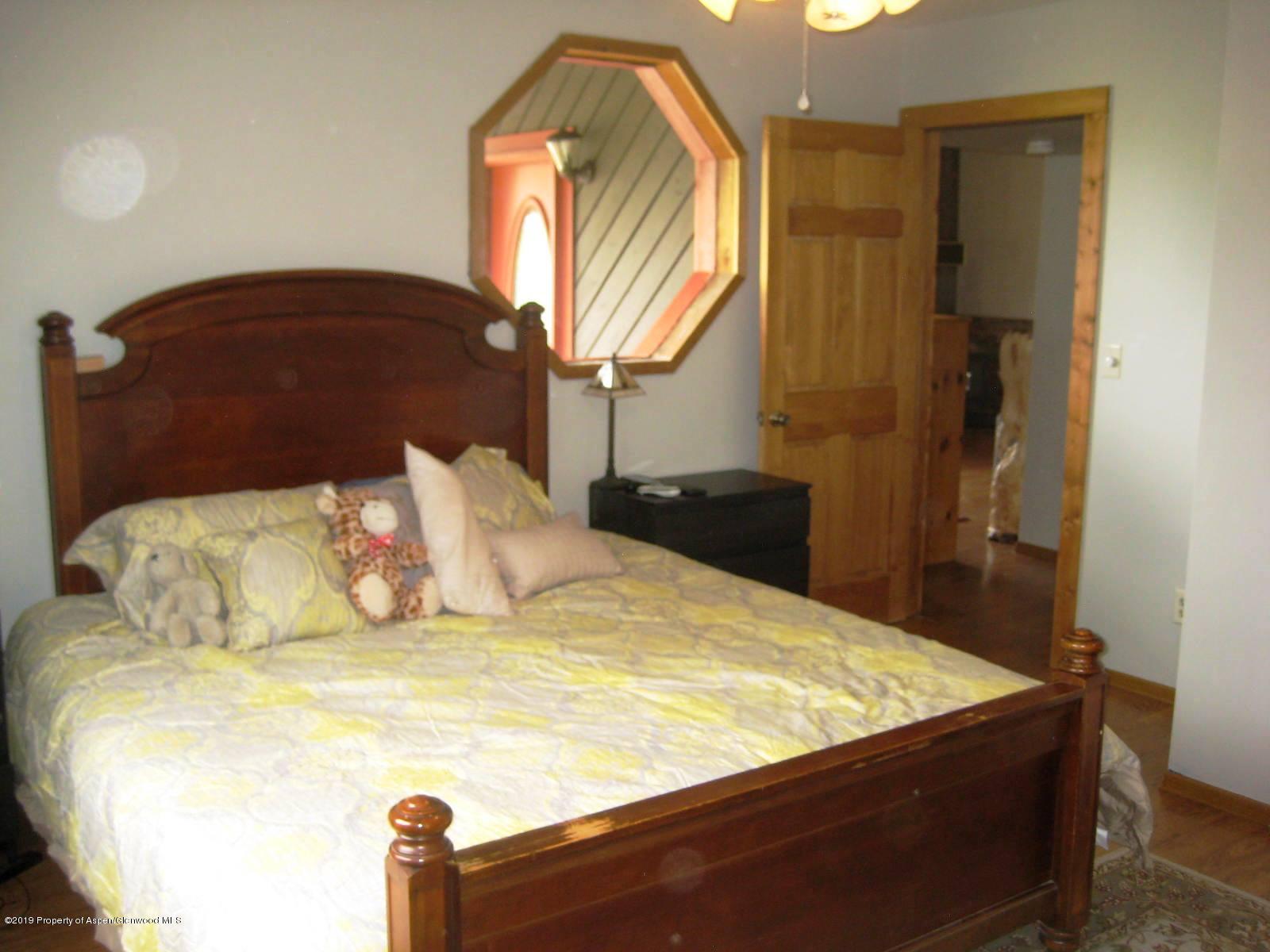 432 East 3rd Street Rifle, CO 81650 - Photo 11 of 20 a bed sitting in a bedroom next to a window