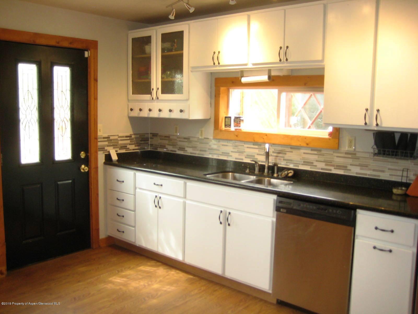 432 East 3rd Street Rifle, CO 81650 - Photo 4 of 20 a kitchen with granite countertop a sink window and cabinets