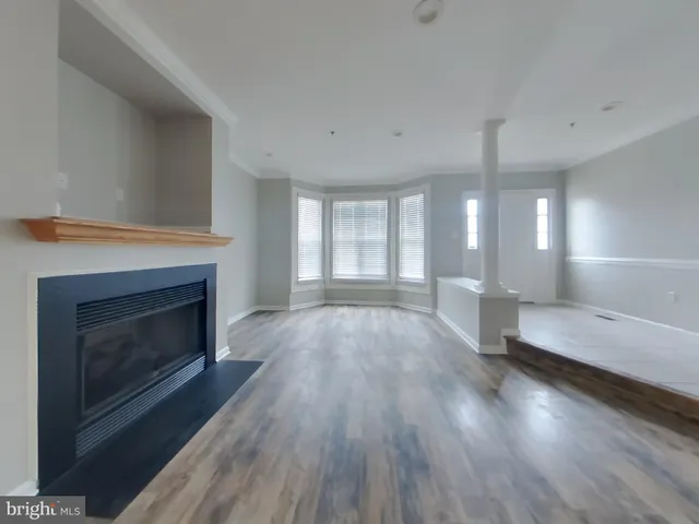 a large living room with a fireplace and wooden floor