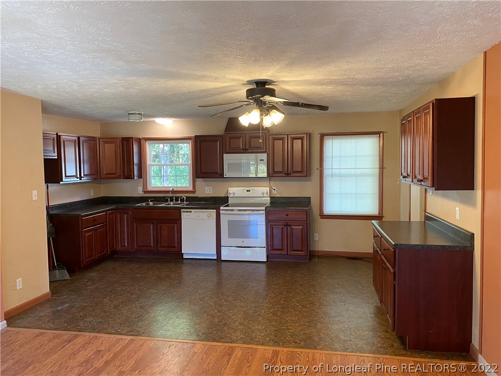 796 Denmark Road Lumberton, NC 28358 - Photo 7 of 21 a large kitchen with granite countertop a large counter top stainless steel appliances and cabinets