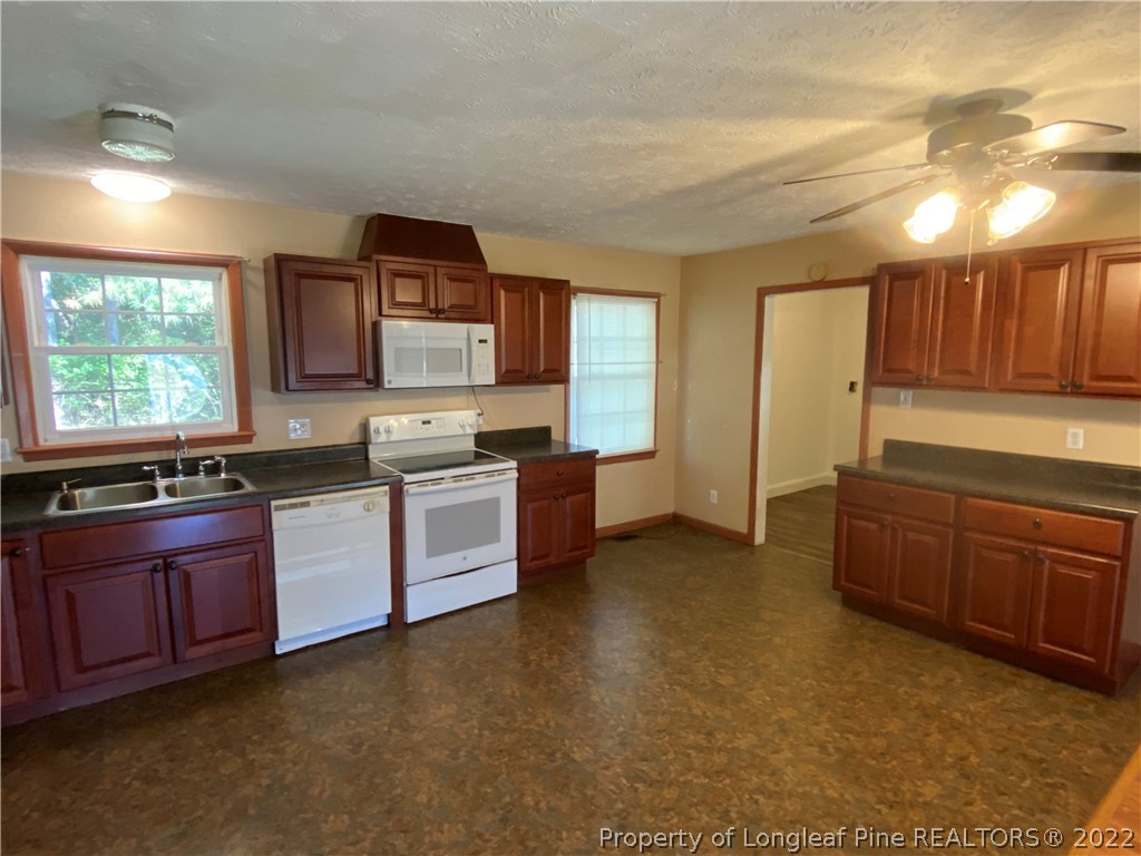 796 Denmark Road Lumberton, NC 28358 - Photo 10 of 21 a kitchen with granite countertop a stove a sink and a refrigerator