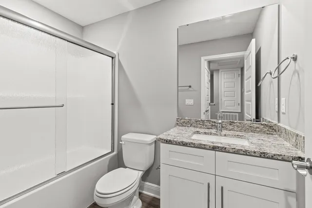 a bathroom with a granite countertop sink toilet and shower