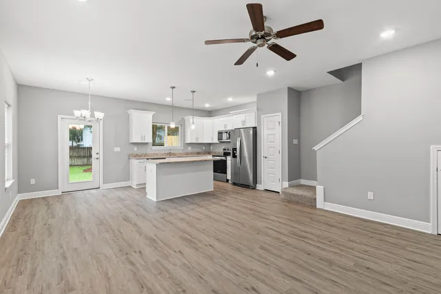 a view of kitchen with granite countertop cabinets and refrigerator