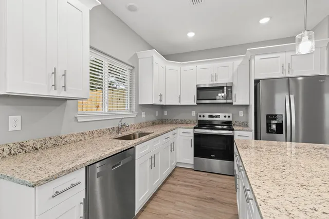 a kitchen with granite countertop a sink and steel appliances