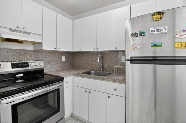 a kitchen with stainless steel appliances granite countertop a sink and a stove