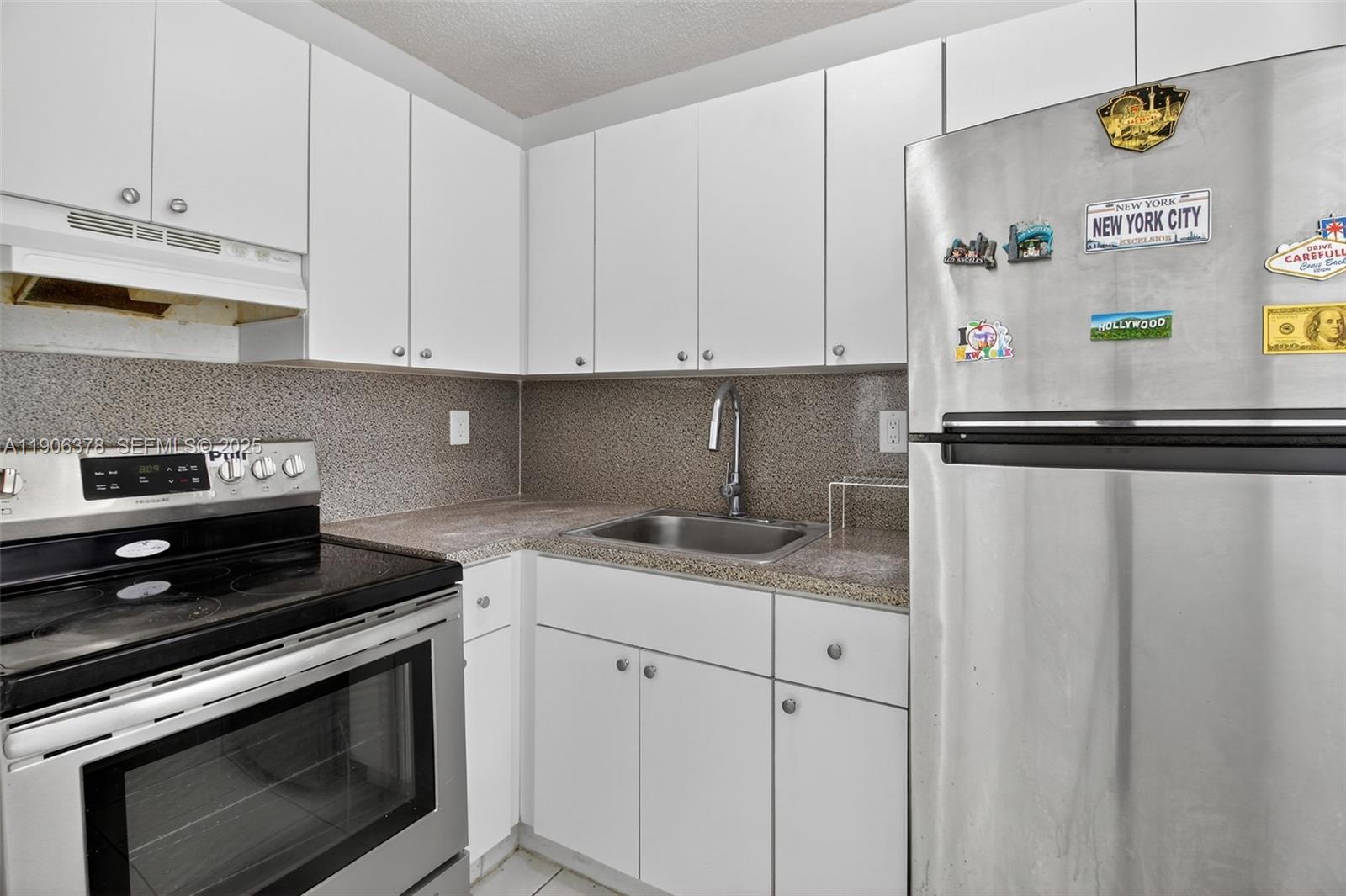 1864 Northwest 28th Street, Unit 1 Miami, FL 33142 - Photo 4 of 16 a kitchen with stainless steel appliances granite countertop a sink and a stove