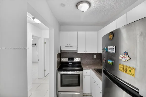 a kitchen with stainless steel appliances granite countertop a refrigerator and a stove