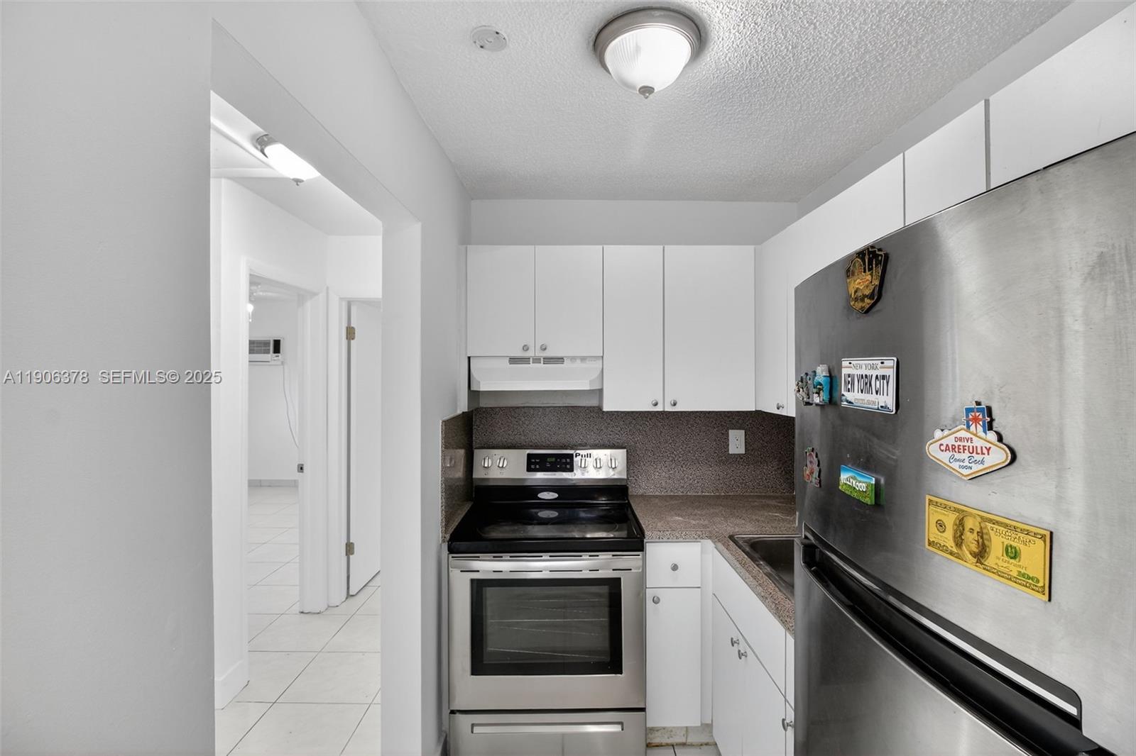 1864 Northwest 28th Street, Unit 1 Miami, FL 33142 - Photo 5 of 16 a kitchen with stainless steel appliances granite countertop a refrigerator and a stove