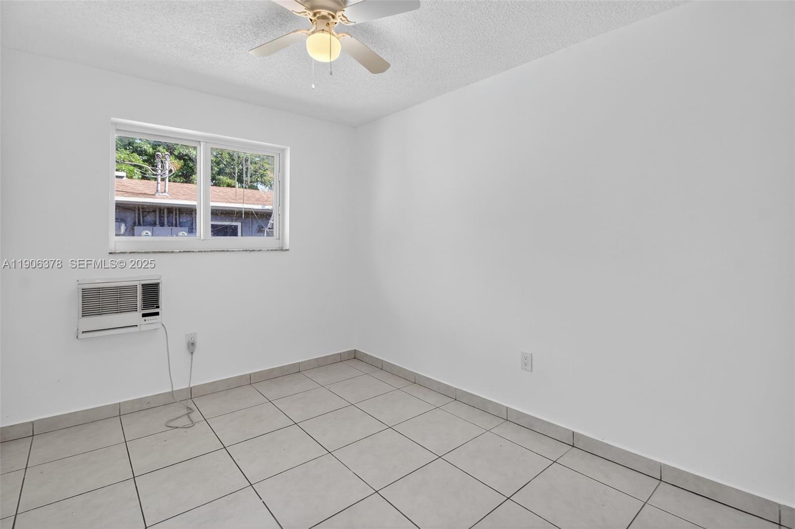 1864 Northwest 28th Street, Unit 1 Miami, FL 33142 - Photo 9 of 16 an empty room with windows and fan