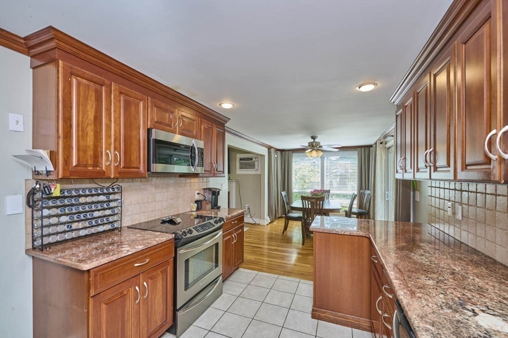 7 Lasallette Road Billerica, MA 01821 - Photo 8 of 35 a kitchen with stainless steel appliances granite countertop a stove a sink and a microwave