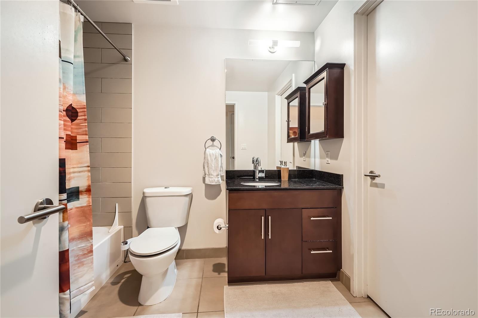 891 14th Street, Unit 2205 Denver, CO 80202 - Photo 13 of 22 a bathroom with a granite countertop sink toilet and shower