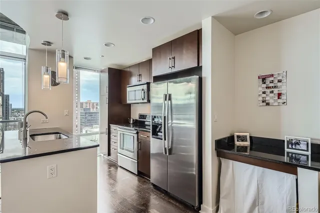 a kitchen with stainless steel appliances granite countertop a refrigerator and a sink