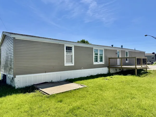 a view of a house with a yard and a wooden deck