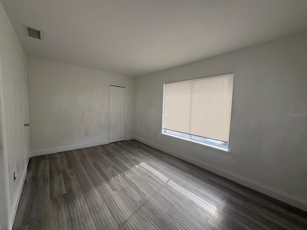 4033 Henley Road, Unit 1707 Orlando, FL 32839 - Photo 52 of 66 an empty room with wooden floor and windows