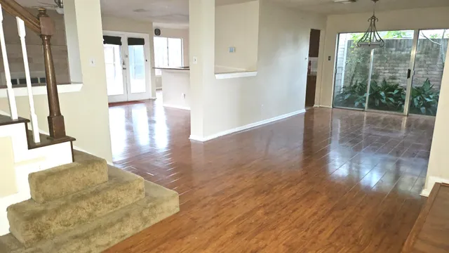 a view of a living room with hardwood floor and large windows