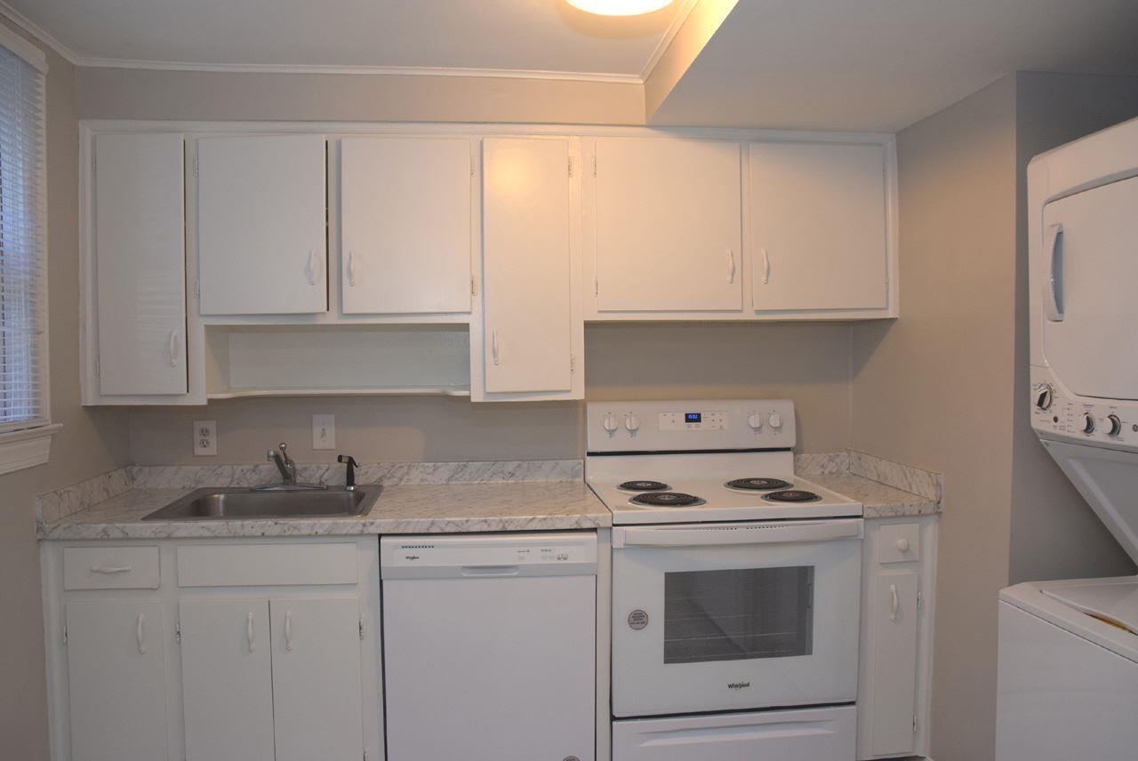 1057 Nichols Drive Raleigh, NC 27605 - Photo 14 of 39 a kitchen with granite countertop white cabinets and white appliances