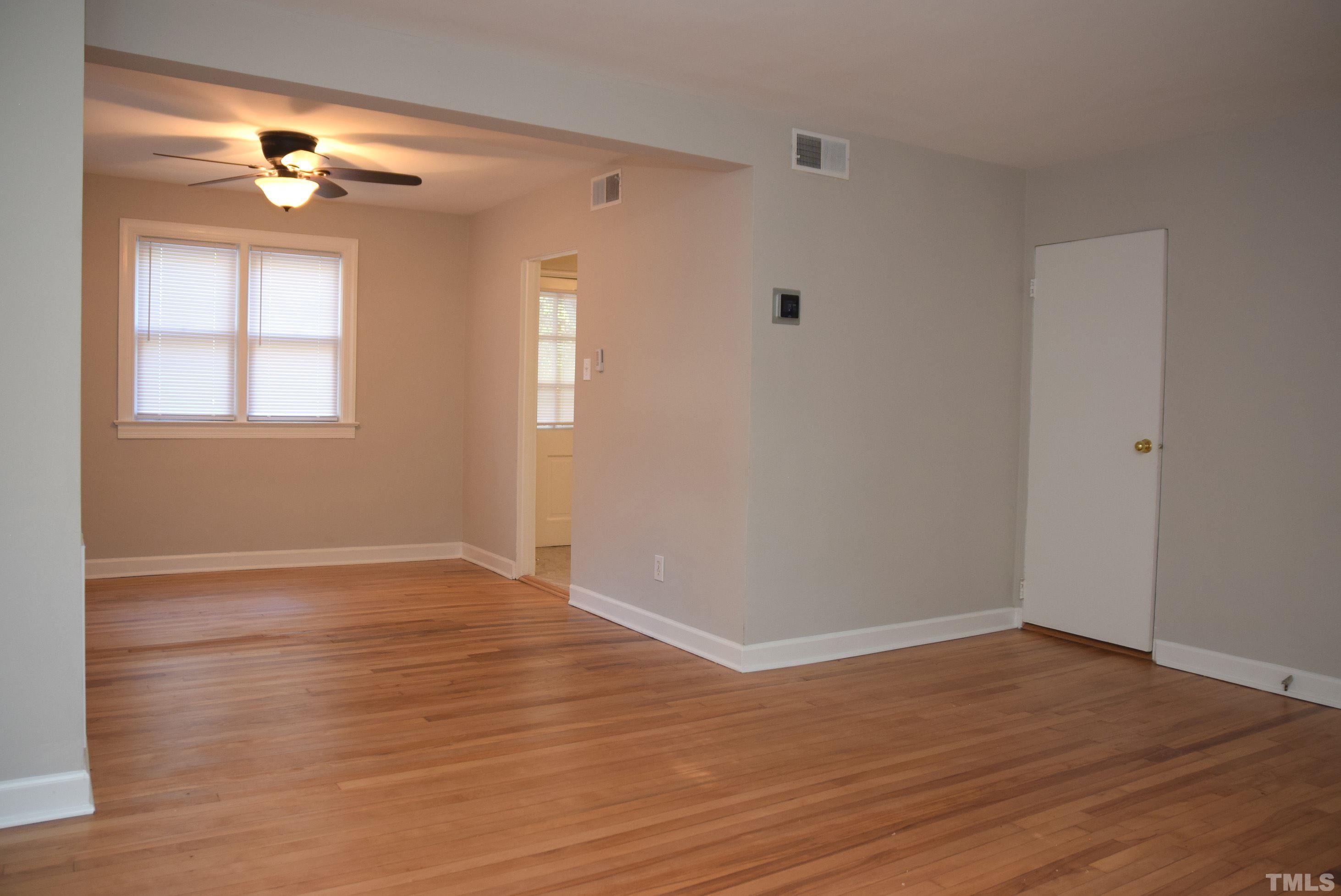 1057 Nichols Drive Raleigh, NC 27605 - Photo 4 of 39 a view of an empty room with wooden floor and a window