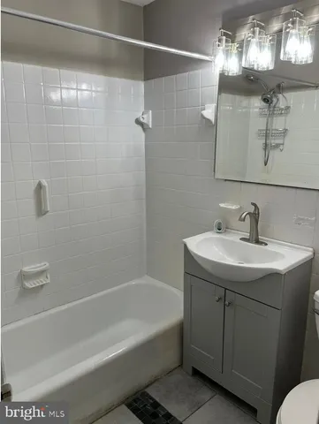 a bathroom with a granite countertop sink a toilet and shower