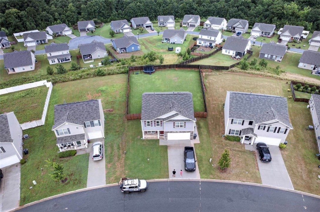 213 Millhone Way Pendleton, SC 29670 - Photo 23 of 25 An aerial perspective showcases a residential neighborhood with houses featuring attached garages and ample yard space.
