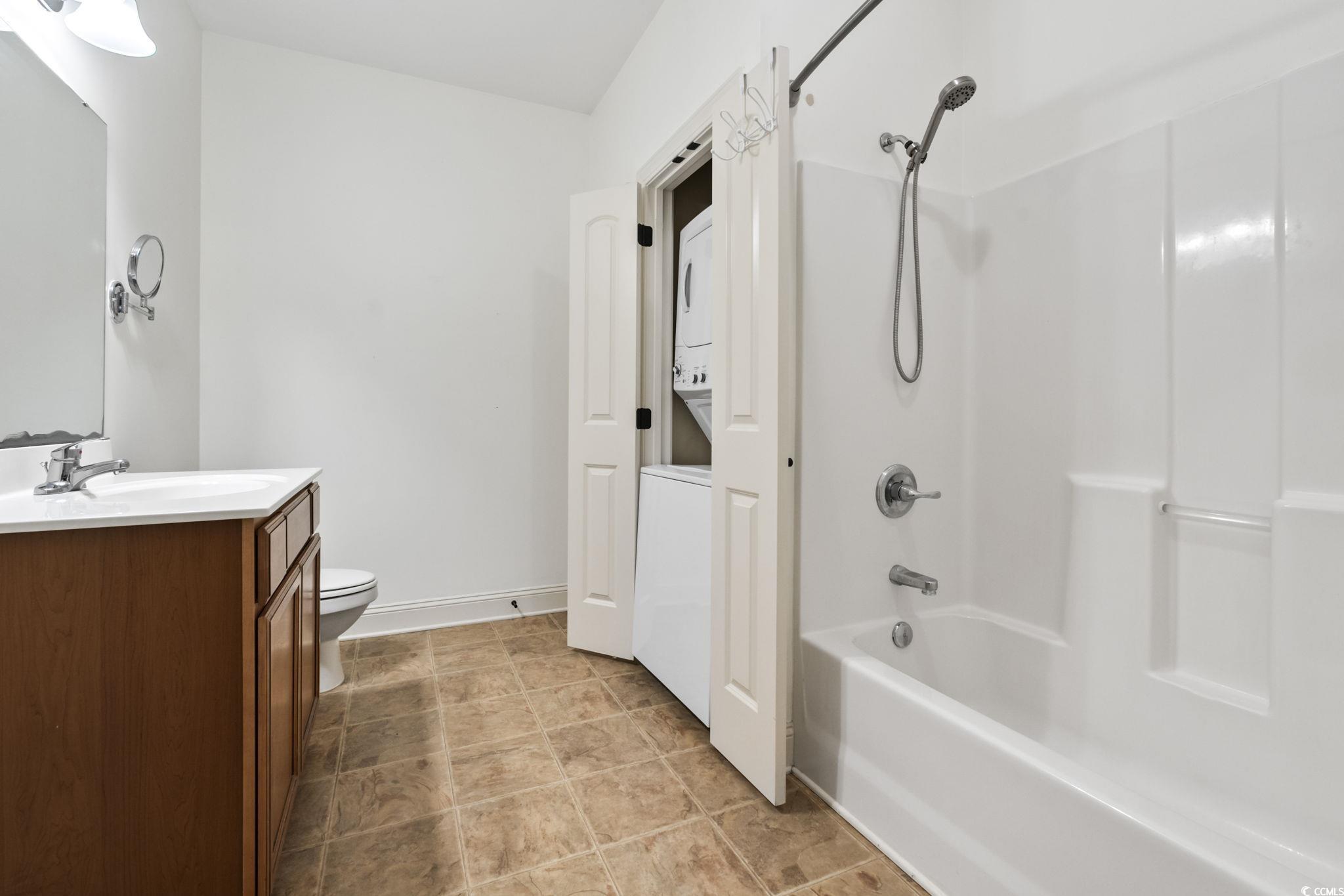 118 Ella Kinley Circle, Unit 404 Myrtle Beach, SC 29588 - Photo 13 of 22 Full bath with stacked washer / drying machine, vanity, and shower combination