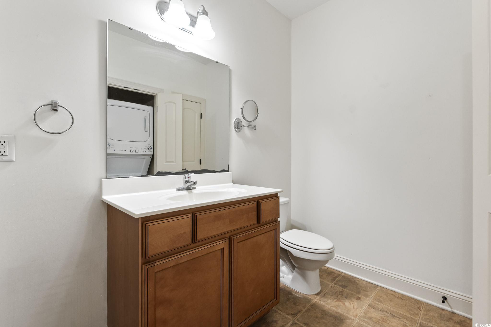 118 Ella Kinley Circle, Unit 404 Myrtle Beach, SC 29588 - Photo 14 of 22 Half bathroom with vanity and stacked washer / dryer