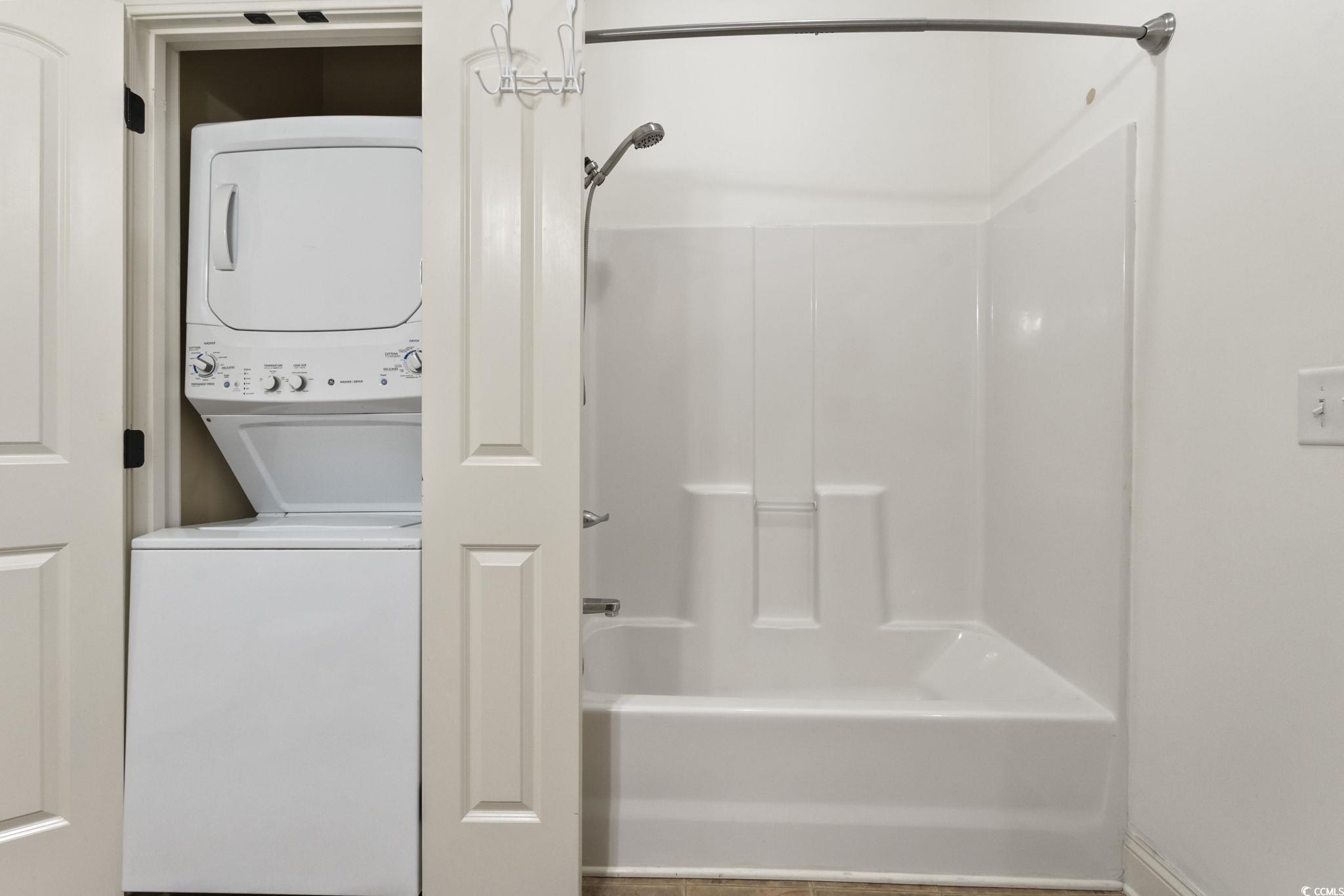 118 Ella Kinley Circle, Unit 404 Myrtle Beach, SC 29588 - Photo 15 of 22 Full bath featuring stacked washing machine and dryer and tub / shower combination